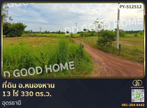 Land for sale with clear open area, greenery, and access road