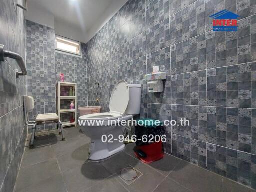 Bathroom with tiled walls and floor, toilet, and shelving