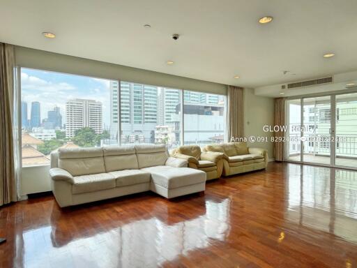 Spacious living room with large windows and city view