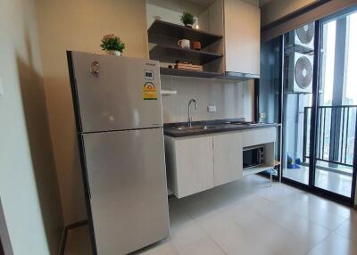 Modern kitchen with stainless steel refrigerator, built-in microwave, and outside view