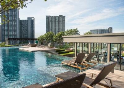Modern pool area with lounge chairs and city view
