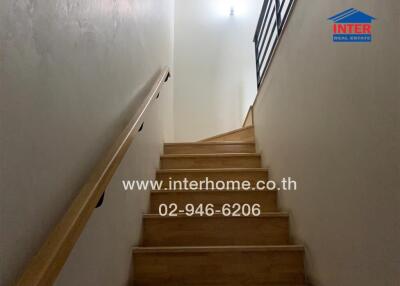 Indoor staircase leading to an upper floor with a handrail