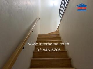 Indoor staircase leading to an upper floor with a handrail