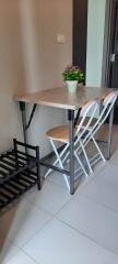 Small dining setup in the kitchen with two chairs, a folding table, and a plant centerpiece