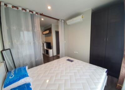 Modern bedroom with a large bed, air conditioning, wardrobe, and partition curtain