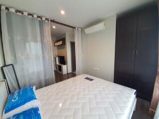 Modern bedroom with a large bed, air conditioning, wardrobe, and partition curtain