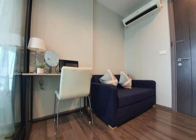 Modern small living area with desk, chair, sofa, and air conditioner