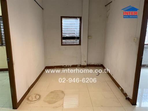 Interior view of an empty room with a tiled floor and a small window