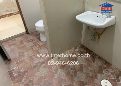 Basic bathroom with tiled floor, toilet, and hand sink