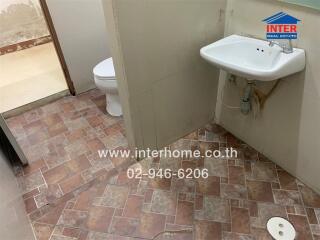 Basic bathroom with tiled floor, toilet, and hand sink