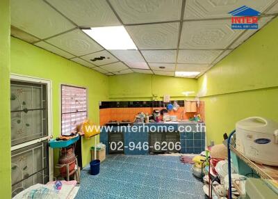 A brightly painted kitchen with various appliances and utensils