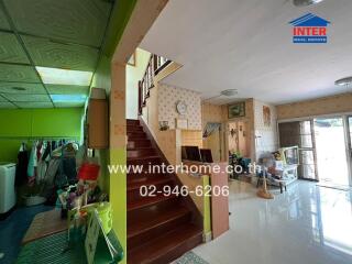 Interior view of a house with a staircase, living area, and laundry corner