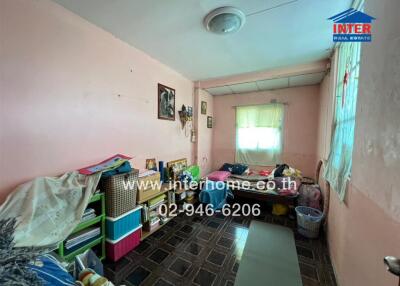 Messy bedroom with various personal items and decorations on the walls