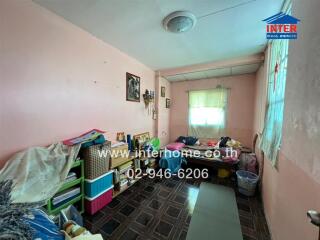 Messy bedroom with various personal items and decorations on the walls