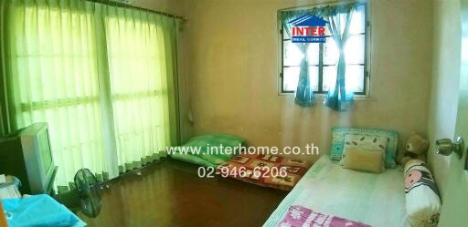 Spacious bedroom with two beds and natural lighting