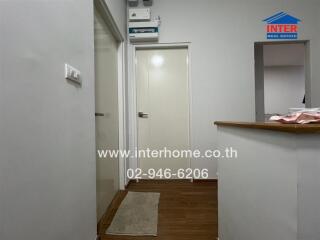 Hallway with wooden flooring and white walls