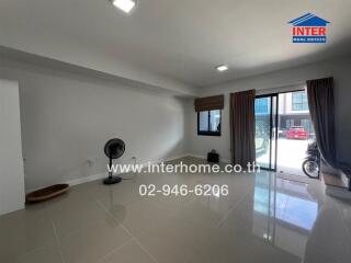 Spacious living room with modern tiled flooring and natural light