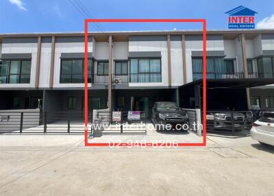 Front view of residential building with vehicles parked in garage