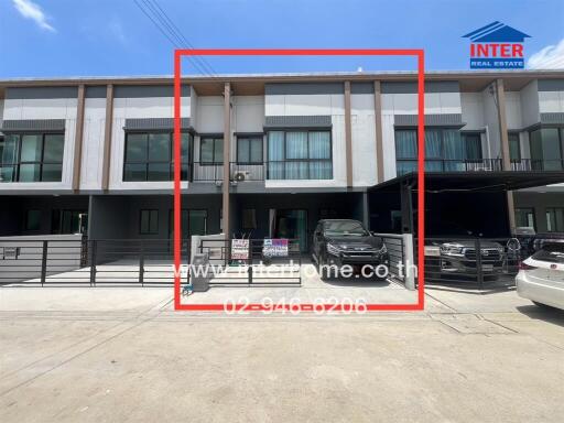 Front view of residential building with vehicles parked in garage