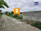 Outdoor view of a road next to a concrete wall and fields