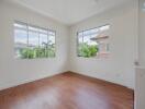 Bright bedroom with hardwood floors and large windows