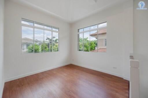 Bright bedroom with hardwood floors and large windows