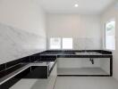 Minimalist modern kitchen with large sink and marble backsplash