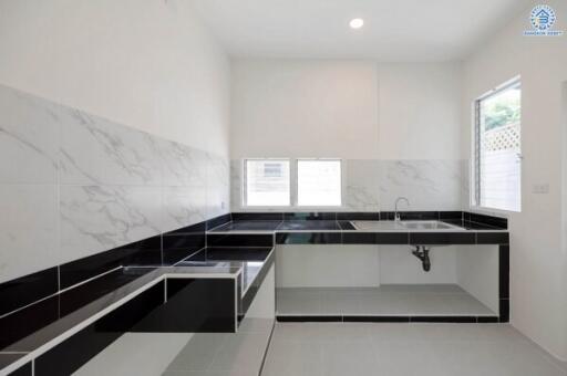 Minimalist modern kitchen with large sink and marble backsplash