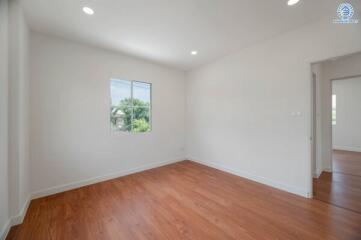 Empty bedroom with hardwood flooring and window