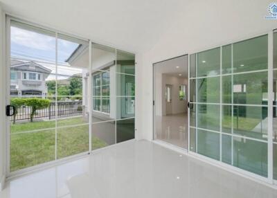 Spacious living area with large glass doors opening to a green lawn