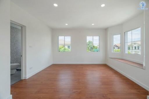 Bright and spacious empty living room with large windows and hardwood floors