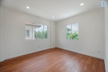 Spacious empty bedroom with wooden flooring