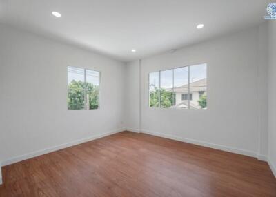 empty room with wooden flooring and large windows