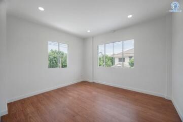 empty room with wooden flooring and large windows