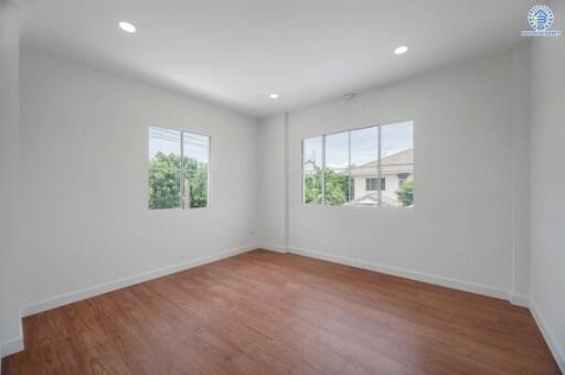 empty room with wooden flooring and large windows