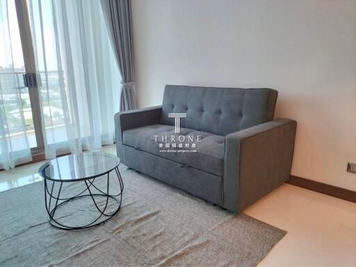 Modern living room with a grey sofa and a round glass coffee table