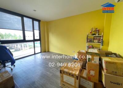 Room with yellow walls, large windows, and boxes