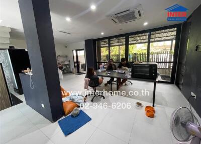 Family sitting at a table in a spacious living area with various amenities.
