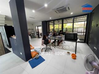 Family sitting at a table in a spacious living area with various amenities.