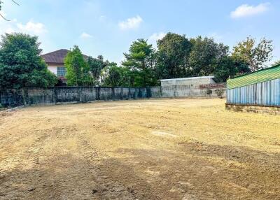 Vacant land with boundary wall and surrounding trees