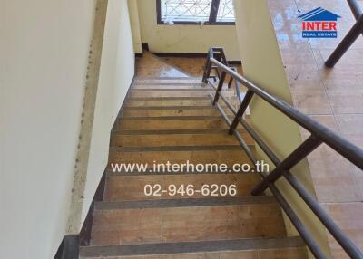 Indoor staircase with wooden steps and a metal handrail