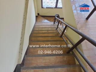 Indoor staircase with wooden steps and a metal handrail