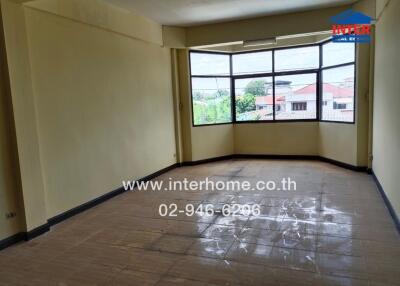 Spacious living room with large windows and tiled floor