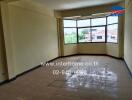 Spacious living room with large windows and tiled floor