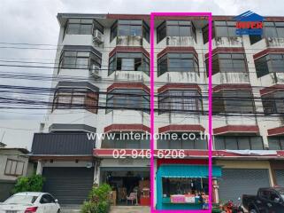 Front view of a commercial building with multiple floors and shopfronts