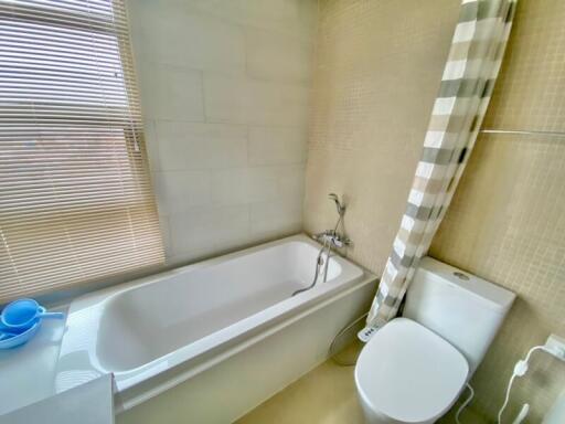 Well-lit bathroom with bathtub and toilet