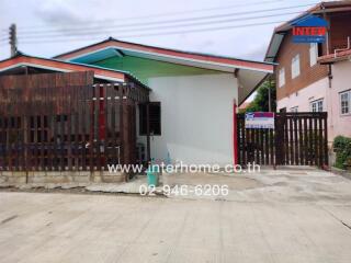 Exterior view of house with driveway and wooden fence