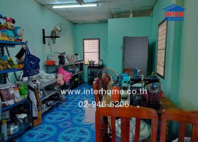 A kitchen with blue flooring, wooden chairs, and various appliances.