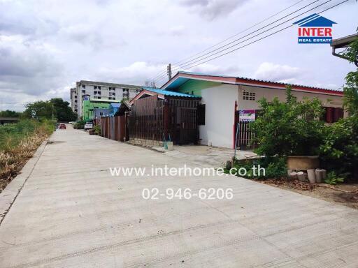 View of a residential property with pathway and adjacent buildings