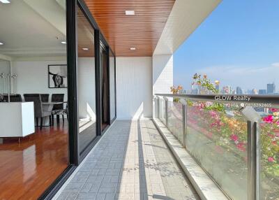 Spacious balcony with glass railing and city view